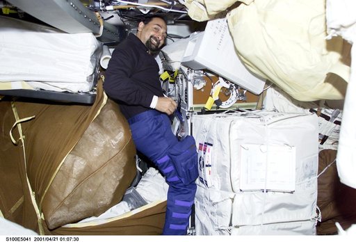 MS Guidoni works among stowage bags on the middeck of Endeavour
