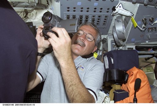MS Phillips uses a video camera on the flight deck of Endeavour during STS-100
