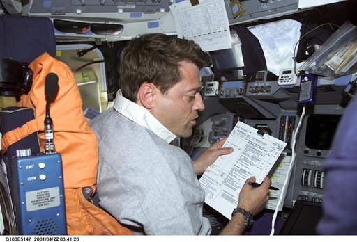 Pilot Ashby reviews a checklist at the commander's workstation on the flight deck of Endeavour