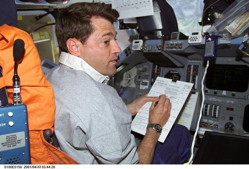 Pilot Ashby reviews a checklist at the commander's workstation on the flight deck of Endeavour