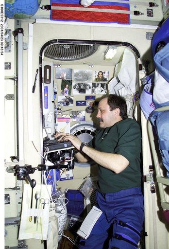 Usachev works at his laptop computer in Zvezda during STS-100's ingress