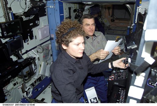 Helms and Voss work at the SSRMS control station in the U.S. Laboratory during STS-100