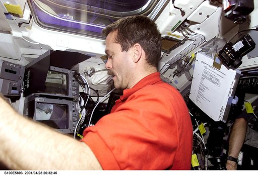 MS Hadfield works at the RMS controls on the flight deck of Endeavour