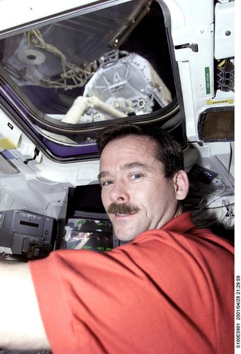 MS Hadfield works at the RMS controls on the flight deck of Endeavour during RMS handshake