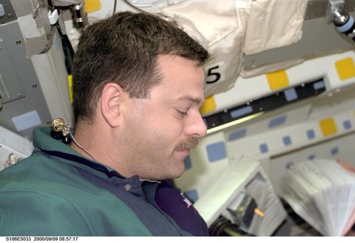 Pilot Altman at work aboard Atlantis during STS-106
