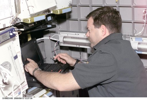 Pilot Altman works with the SOAR laptop computer in SpaceHab during STS-106