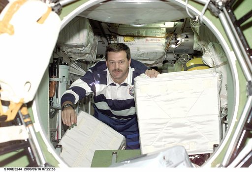 Pilot Altman transfers stowage equipment into the ISS during STS-106