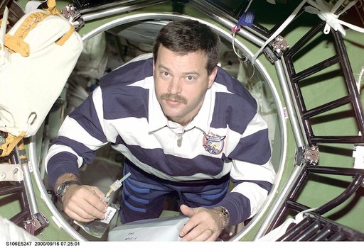 Pilot Altman moves through a hatch in the ISS during STS-106