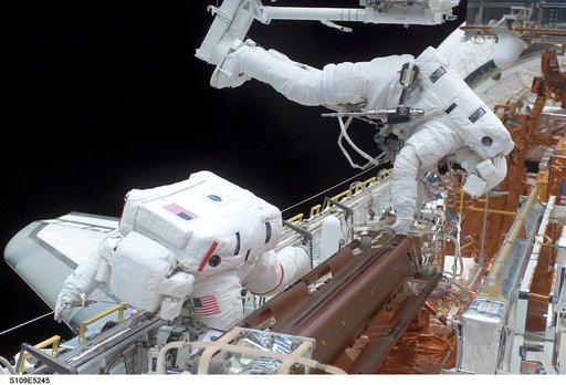 STS-109 MS Grunsfeld and Linnehan stow old solar array from payload bay