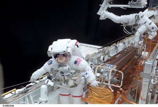 STS-109 MS Grunsfeld and Linnehan stow old solar array from payload bay