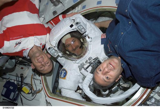 MS Grunsfeld wearing EMU in Airlock joined by MS Newman and Massimino