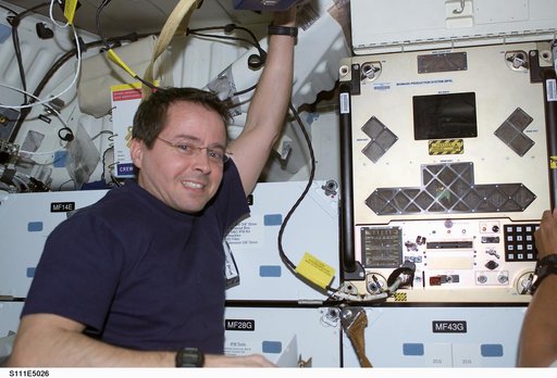 Bursch poses next to BPS installed in a slot on Endeavour's middeck for return on STS-111 UF-2