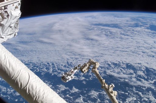 Chang-Diaz on the Canadarm2 SSRMS backdropped against Earth limb during  STS-111 UF-2 EVA 1