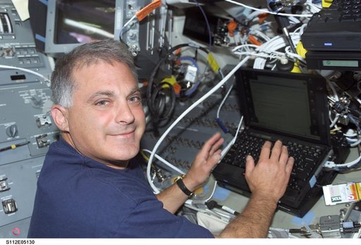 MS Wolf on orbiter Atlantis flight deck with laptop