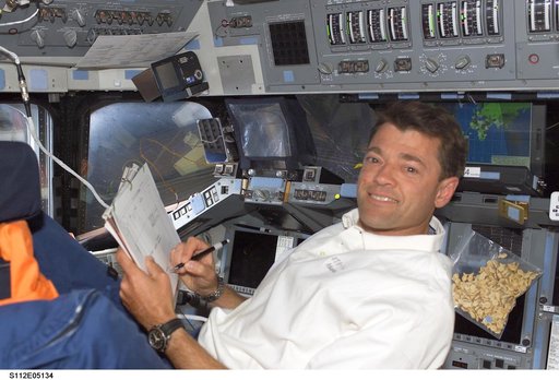 CDR Ashby on flight deck with checklist