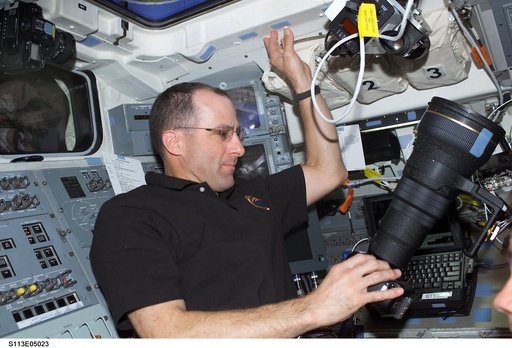 Expedition Six Flight Engineer Don Pettit adjusts camera on AFD during STS-113
