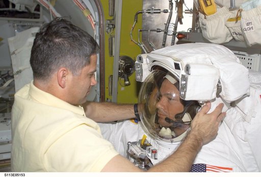 EVA Prep OPS - PLT Lockhart assists MS Lopez-Alegria with EMU Helmet during STS-113