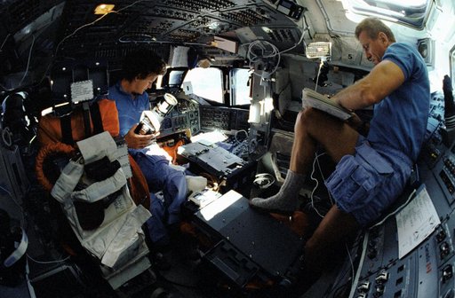 STS-31 MS Sullivan and Commander Shriver work on the OV-103's flight deck