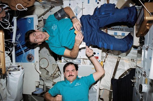 STS-35 payload specialists perform balancing act on OV-102's middeck