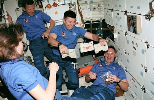 STS-37 crewmembers watch Pilot Cameron juggle cassettes on OV-104's middeck