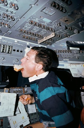 STS-43 Pilot Baker eats a sandwich on OV-104's forward flight deck