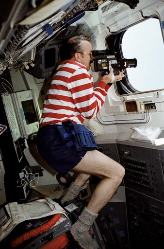 STS-43 Mission Specialist (MS) Adamson uses camera on aft flight deck