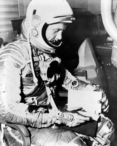 Astronaut John Glenn looks over checklist during MA-6 preflight activity