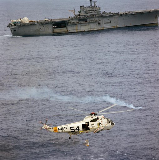 Apollo 9 crewman in rescue net being hoisted up to helicopter