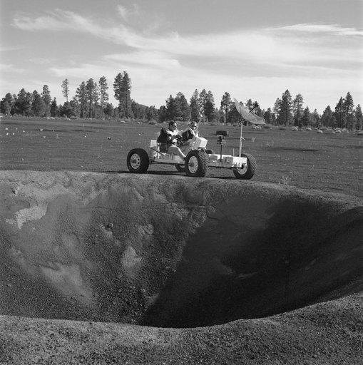 Apollo 15 crewmen riding lunar roving vehicle simulator during geology trip