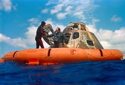 Apollo 14 astronauts assisted out of Command Module by Navy divers