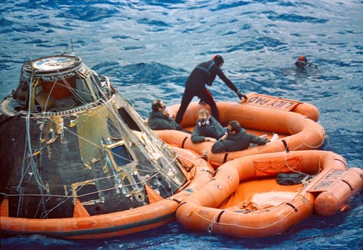 Apollo 14 astronauts assisted out of Command Module by Navy divers