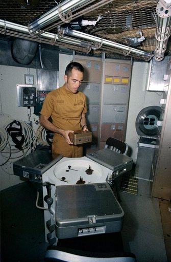 Astronaut Robert Crippen holds training model of Skylab experiment