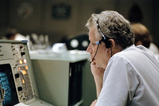 Terry White seated at the public affairs console STS-8