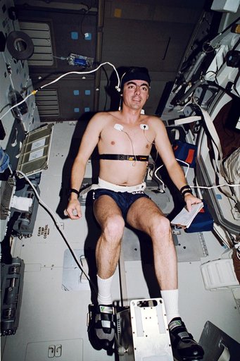 STS-46 Pilot Allen uses cycle ergometer on OV-104's middeck