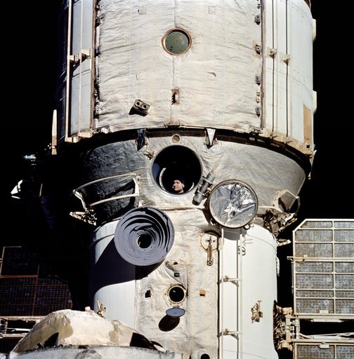 Cosmonaut Valeriy Polyakov seen in Mir's window from Shuttle Discovery