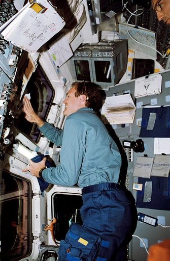 STS-65 Pilot Halsell cleans window on the aft flight deck of Columbia, OV-102