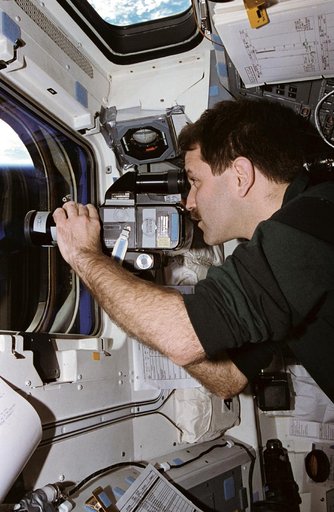 Astronaut John Grunsfeld uses camera to record ASTRO-2 payload