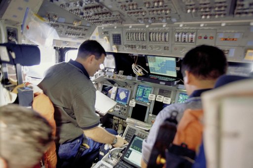 Pilot Altman and MS Lu work on the flight deck during docking to ISS