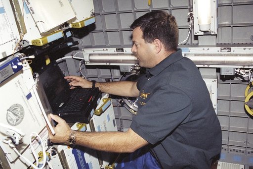 Pilot Altman works with the SOAR laptop computer in SpaceHab during STS-106