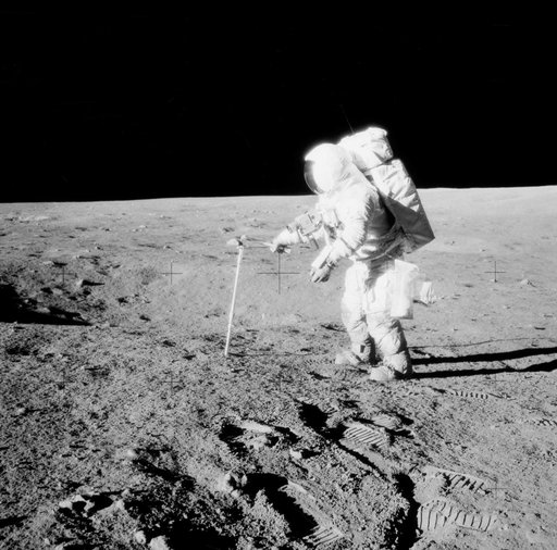 Astronaut Alan Bean drives core sample tube into lunar surface