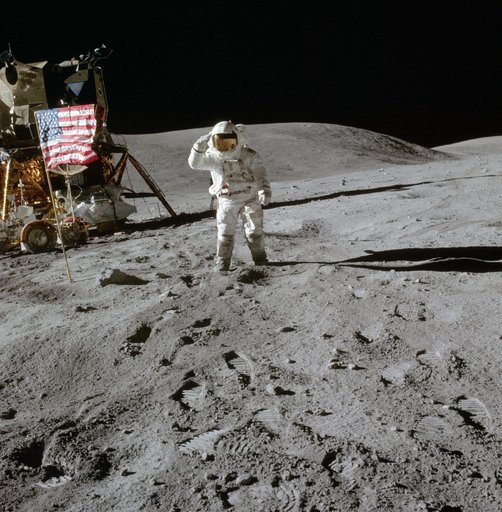 Apollo 16 Mission image - View of Station Lunar Module (LM) and Lunar Module Pilot (LMP), Charles M. Duke, Jr., and Flag