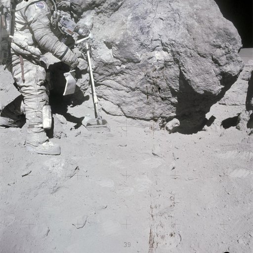 Astronaut Charles Duke stands at rock adjacent to "House Rock"