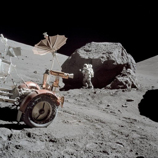 Astronaut Harrison Schmitt standing next to boulder during third EVA