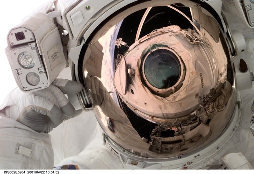 Reflection of Destiny lab window in astronaut faceplate