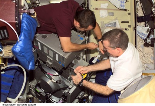 Tyurin and Voss perform maintenance on the TVIS treadmill in the Service Module