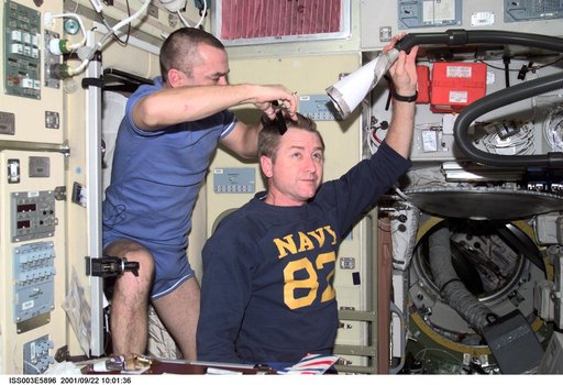 Tyurin gives Culbertson a haircut in the Service Module during Expedition Three
