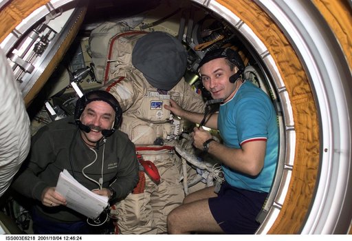 Dezhurov and Tyurin work on an Orlan suit in Pirs during Expedition Three