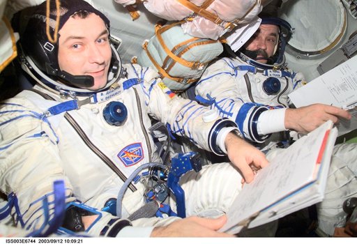 Tyurin and Dezhurov are seated in the Soyuz spacecraft during Expedition Three