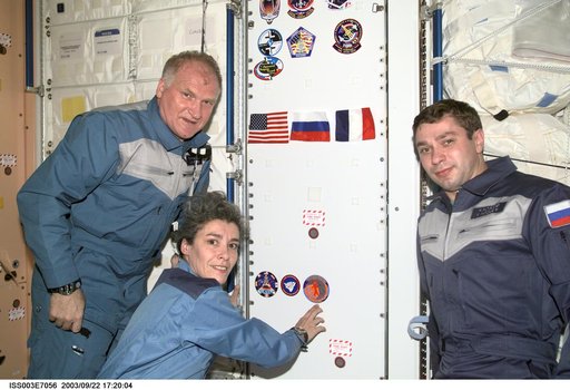 The Soyuz Taxi crew adhere their logo to a wall in Node 1 during Expedition Three
