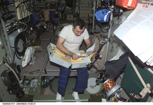 Dezhurov looks through a stowage container in Zvezda during Expedition Three